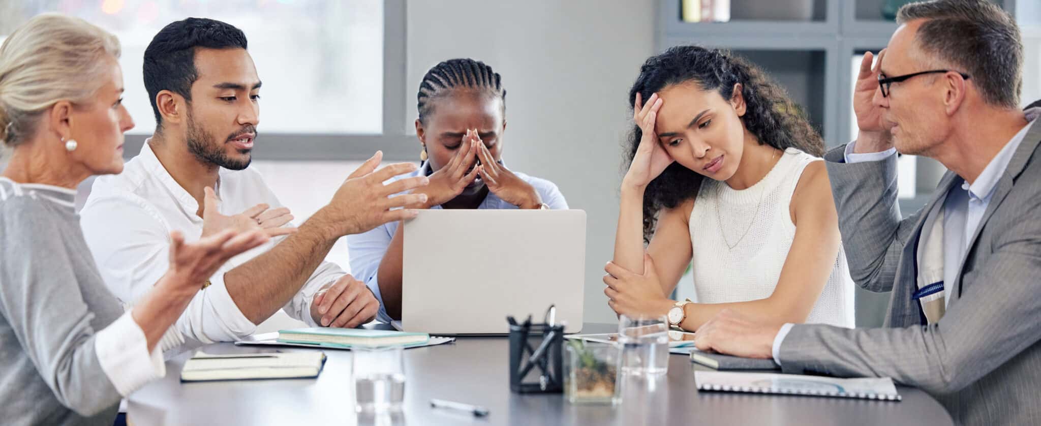 Bad Hire | Shot of a group of businesspeople looking stressed out while working together in an office