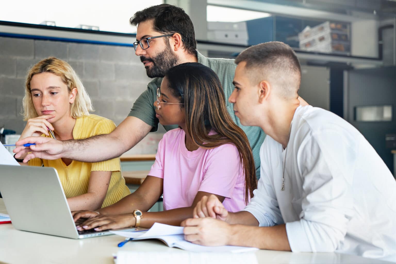 Students at work. International School of Finance Technology and Science. Young teacher. Helping teacher.