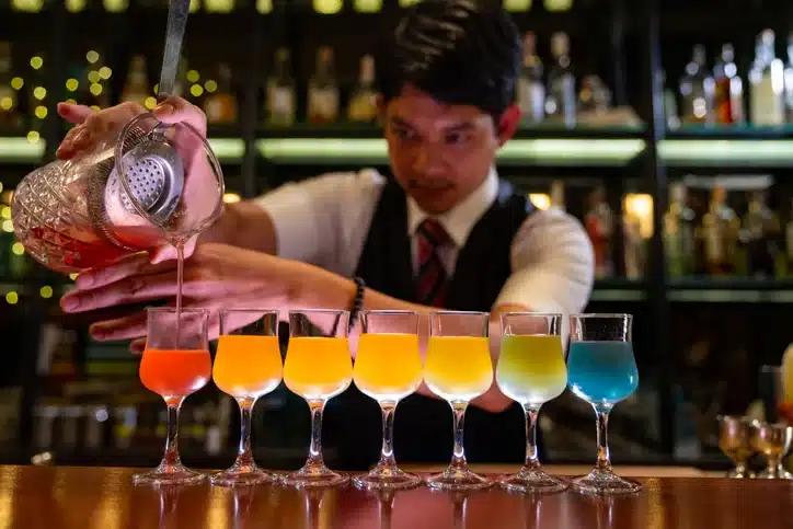 TemPositions Eden Hospitality | Bartender Jobs | Server Jobs Description | Man mixes drinks of different color