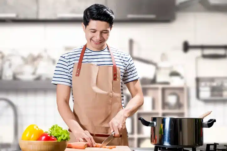 TemPositions Eden Hospitality | Cook Jobs | Server Jobs Description | Man chops vegetables on kitchen table