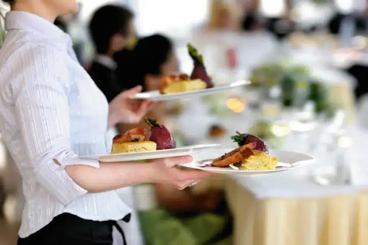 TemPositions Eden Hospitality | Server Jobs | Server Jobs Description | Woman Serves Food at a Banquet